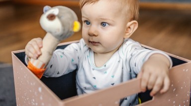 bébé jouant avec une peluche