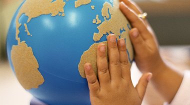 Decouvrir le monde et geographie ecole primaire - globe terrestre et mains d'enfants globe terrestre et mains d'enfants